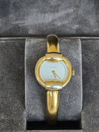 MODEVESTIGE vintage Gucci 1400L gold-plated stainless steel wristwatch with a white dial and bangle-style bracelet.