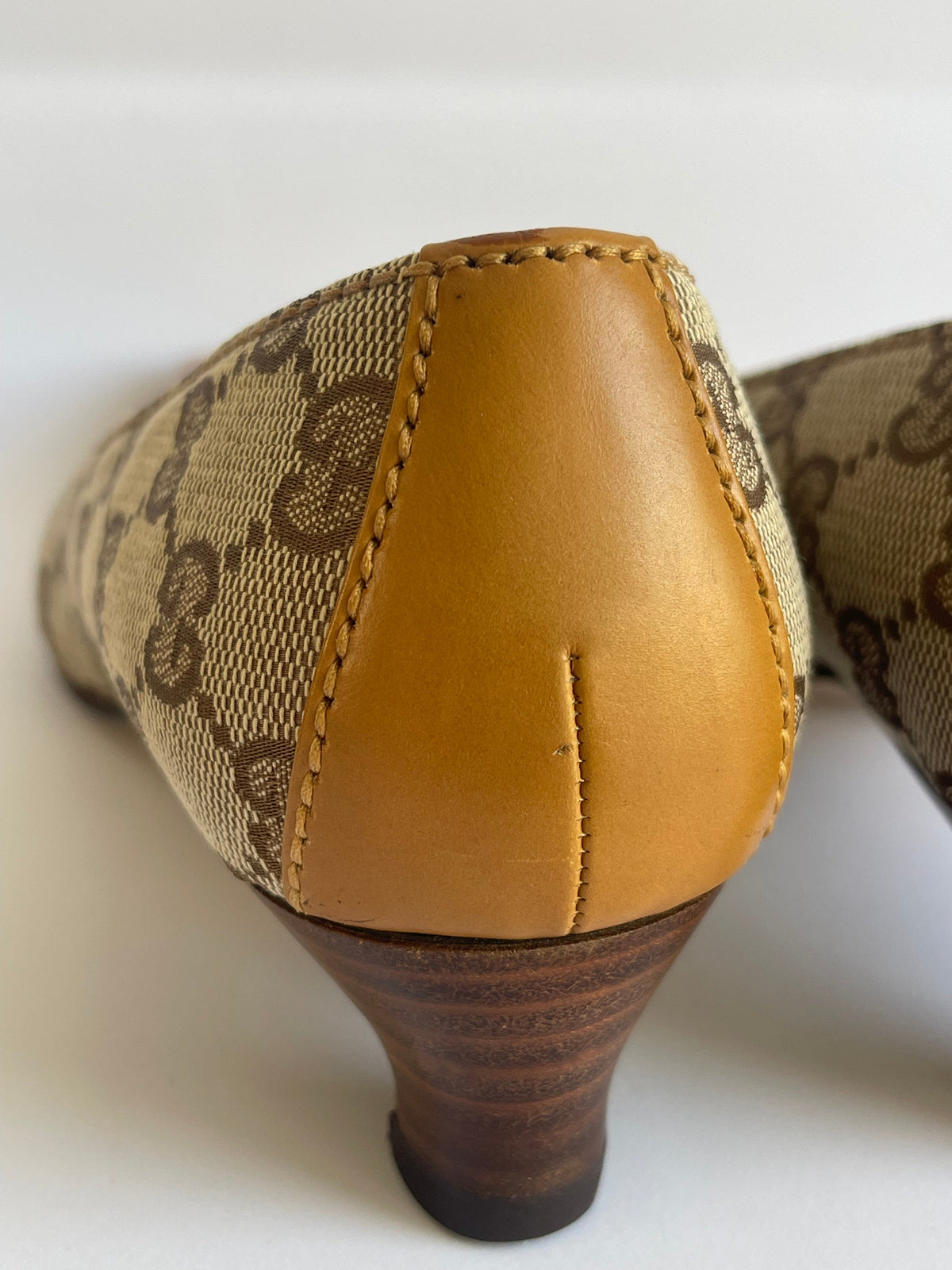 Detalhe do calcanhar de um sapato vintage Gucci MODEVESTIGE em lona GG bege e couro marrom com salto kitten de madeira