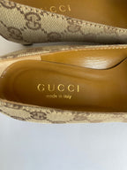 Detalhe interno de scarpin vintage Gucci da MODEVESTIGE em lona bege GG e couro, com palmilha dourada.